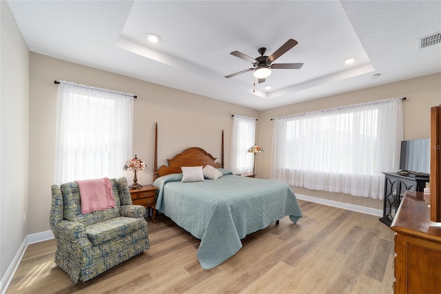 9607 SW 79th Lane Rd, Ocala, FL 34481 - bedroom with a tray ceiling, light wood-type flooring, recessed lighting, multiple windows, and baseboards