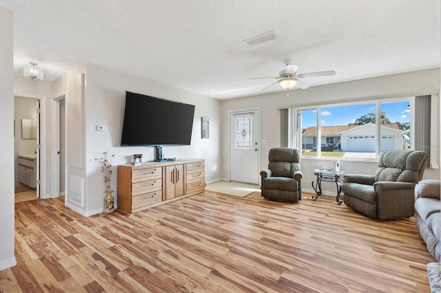 17890 SE 96th Ct, Summerfield, FL 34491 - living area featuring a textured ceiling, light wood finished floors, baseboards, and a ceiling fan