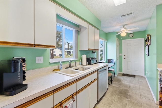 17890 SE 96th Ct, Summerfield, FL 34491 - kitchen featuring dishwasher, light countertops, a sink, white cabinetry, and a textured ceiling