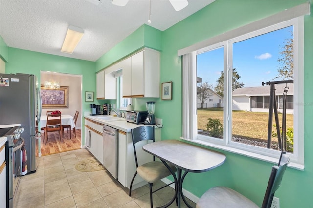 17890 SE 96th Ct, Summerfield, FL 34491 - kitchen featuring appliances with stainless steel finishes, white cabinets, plenty of natural light, a sink, and a textured ceiling