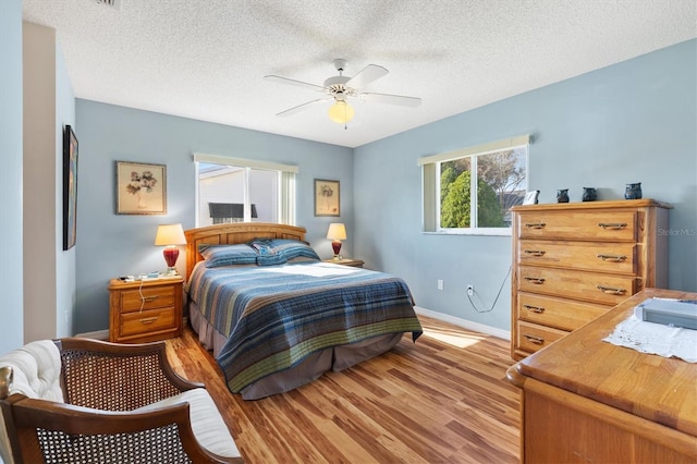 17890 SE 96th Ct, Summerfield, FL 34491 - bedroom with light wood-style flooring, baseboards, a textured ceiling, and ceiling fan
