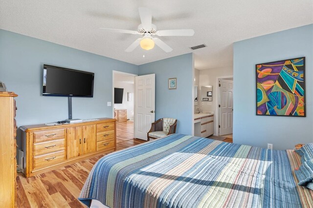 17890 SE 96th Ct, Summerfield, FL 34491 - bedroom with light wood finished floors, ceiling fan, and ensuite bathroom