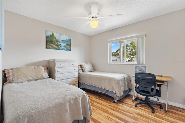 17890 SE 96th Ct, Summerfield, FL 34491 - bedroom featuring light wood-style flooring, baseboards, ceiling fan, and a textured ceiling