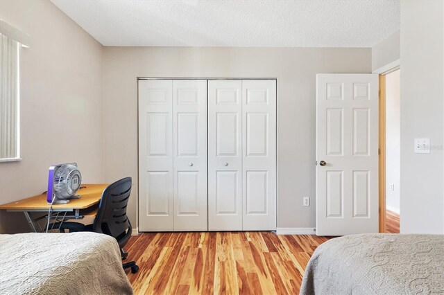 17890 SE 96th Ct, Summerfield, FL 34491 - bedroom featuring a closet, light wood finished floors, an office area, and a textured ceiling