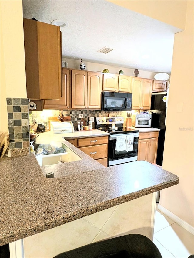 231 NE 28th Ave Unit 207, Ocala, FL 34470 - kitchen featuring black appliances, a peninsula, decorative backsplash, a sink, and light brown cabinets