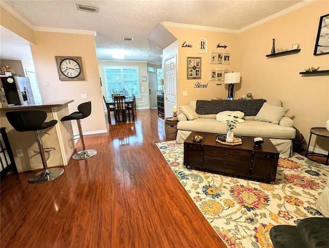 231 NE 28th Ave Unit 207, Ocala, FL 34470 - living area with dark wood-style flooring, baseboards, a textured ceiling, and crown molding