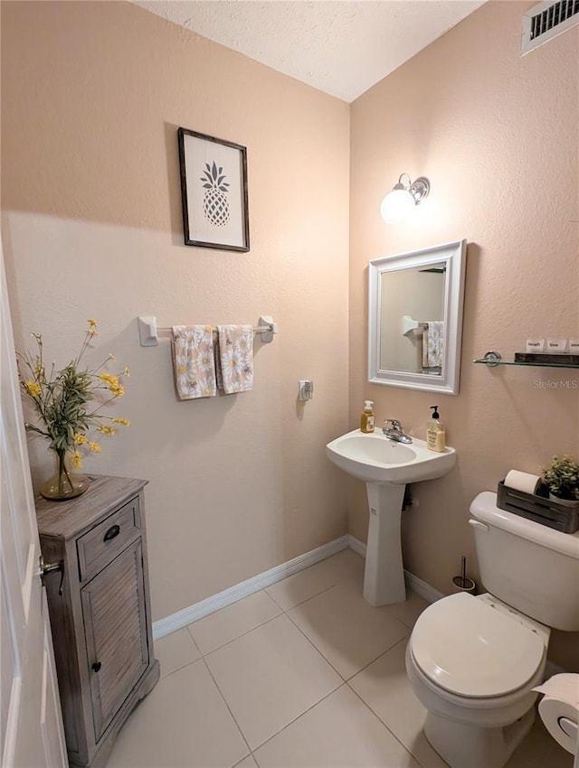 231 NE 28th Ave Unit 207, Ocala, FL 34470 - half bathroom featuring toilet, tile patterned flooring, and baseboards
