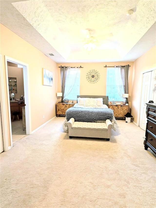 231 NE 28th Ave Unit 207, Ocala, FL 34470 - bedroom featuring a textured ceiling, light colored carpet, baseboards, and ensuite bathroom