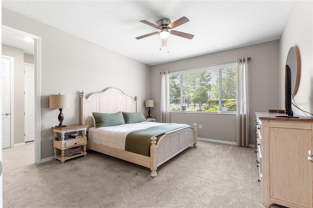 9203 SW 97th Cir, Ocala, FL 34481 - bedroom featuring light colored carpet, baseboards, ceiling fan, and a textured ceiling
