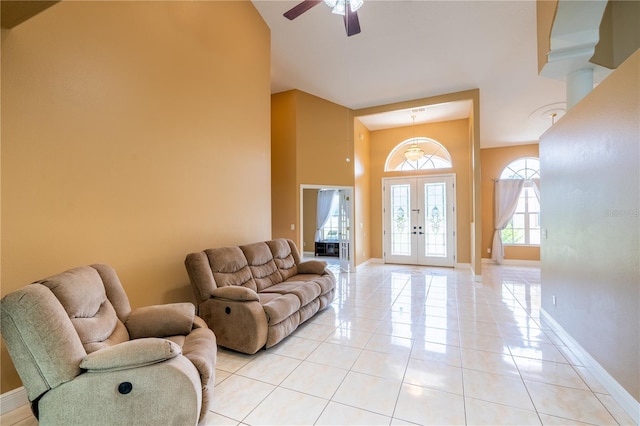 5815 NE 70th St, Silver Springs, FL 34488 - living area with light tile patterned floors, a ceiling fan, a towering ceiling, baseboards, and french doors