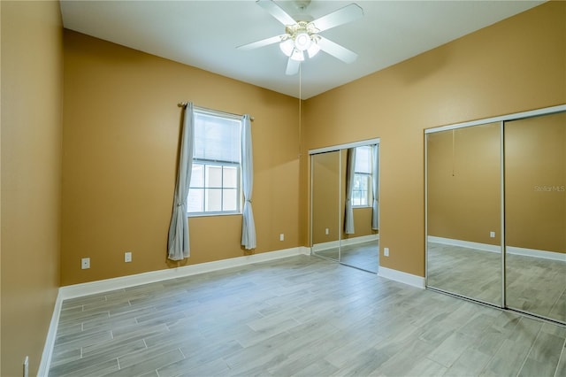 5815 NE 70th St, Silver Springs, FL 34488 - unfurnished bedroom with two closets, light wood-style floors, baseboards, and a ceiling fan