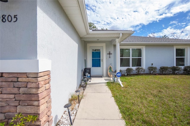 9805 N Dana Way, Citrus Springs, FL 34433 - entrance to property with stucco siding, a yard, and roof with shingles