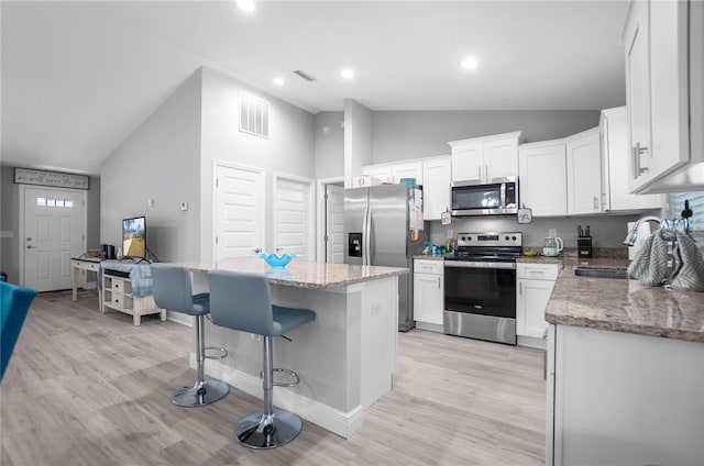 9805 N Dana Way, Citrus Springs, FL 34433 - kitchen featuring stainless steel appliances, a sink, light wood-type flooring, a kitchen island, and white cabinetry