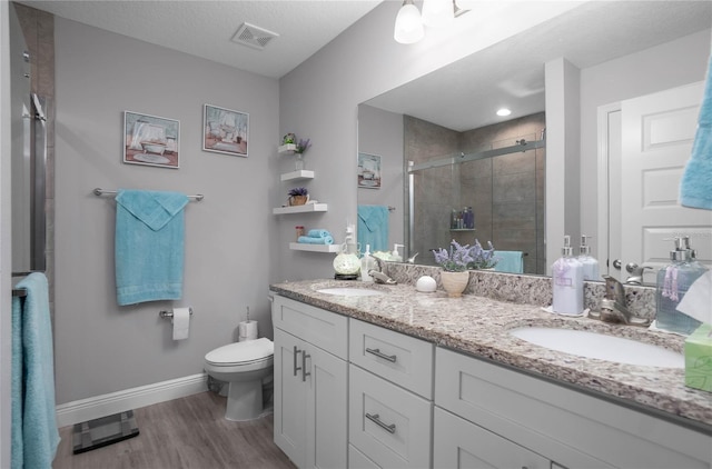 9805 N Dana Way, Citrus Springs, FL 34433 - full bathroom with double vanity, wood finished floors, toilet, baseboards, and a stall shower