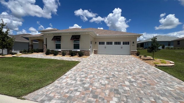 10287 SW 96th Ln, Ocala, FL 34481 - prairie-style home featuring stucco siding, a front yard, decorative driveway, an attached garage, and stone siding