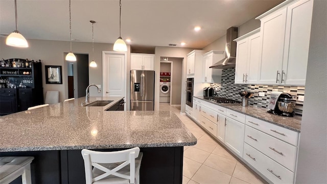 10287 SW 96th Ln, Ocala, FL 34481 - kitchen with stainless steel appliances, a sink, wall chimney range hood, washer / dryer, and light tile patterned floors