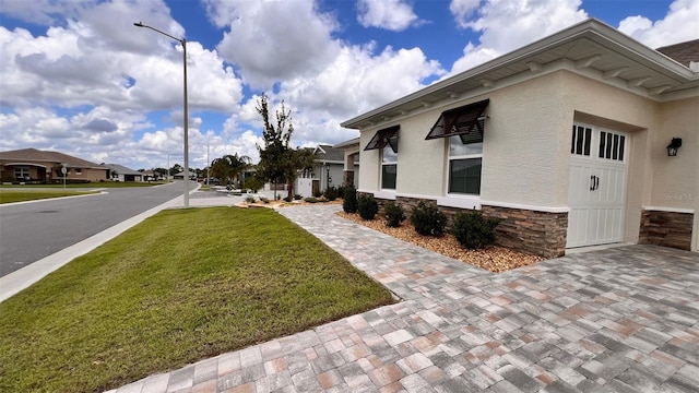 10287 SW 96th Ln, Ocala, FL 34481 - view of side of property with stone siding, a lawn, stucco siding, and a residential view