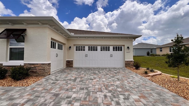 10287 SW 96th Ln, Ocala, FL 34481 - view of front of property with stone siding, decorative driveway, a garage, and stucco siding