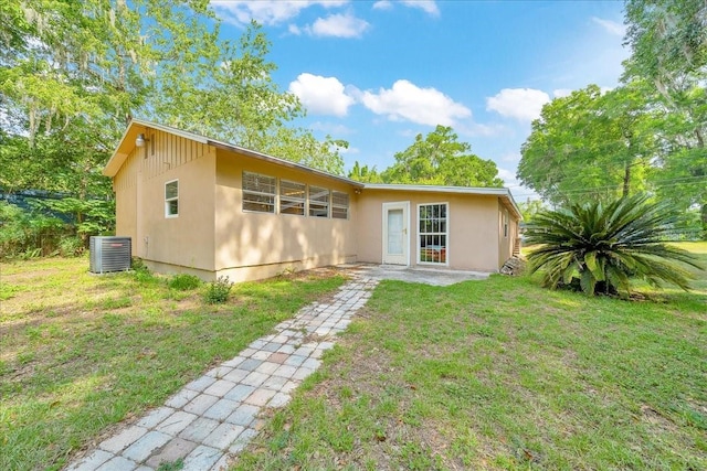 1322 NE 53rd St, Ocala, FL 34479 - rear view of property with a yard, central AC, and stucco siding