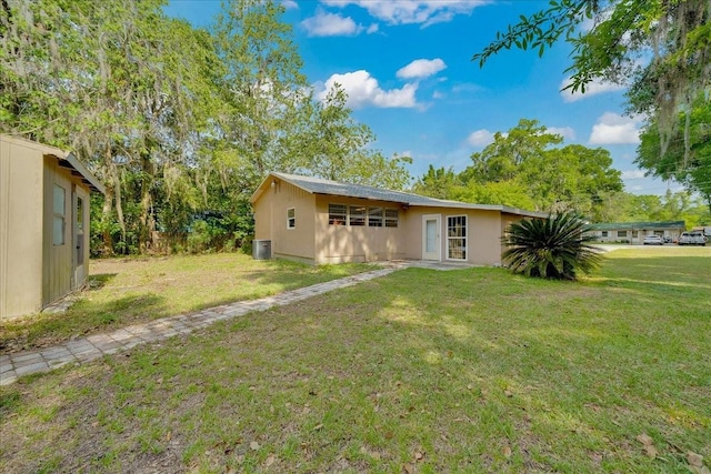 1322 NE 53rd St, Ocala, FL 34479 - rear view of property with a lawn and cooling unit