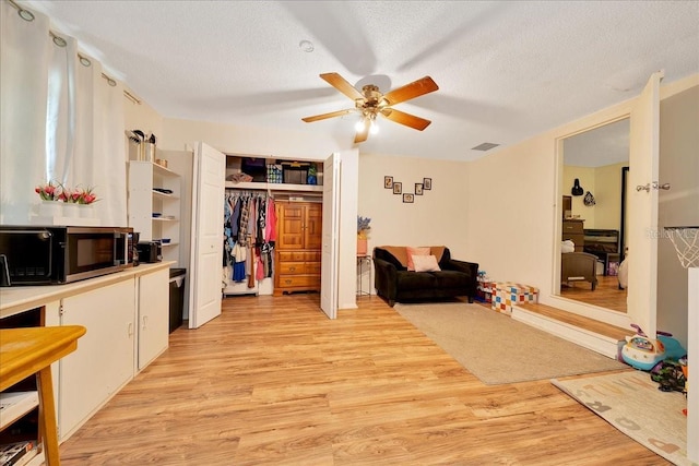 1322 NE 53rd St, Ocala, FL 34479 - living room with ceiling fan, light wood finished floors, and a textured ceiling