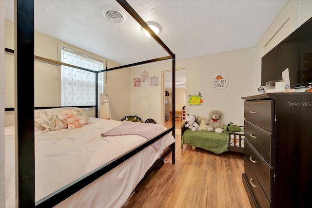 1322 NE 53rd St, Ocala, FL 34479 - bedroom with light wood-type flooring and a textured ceiling