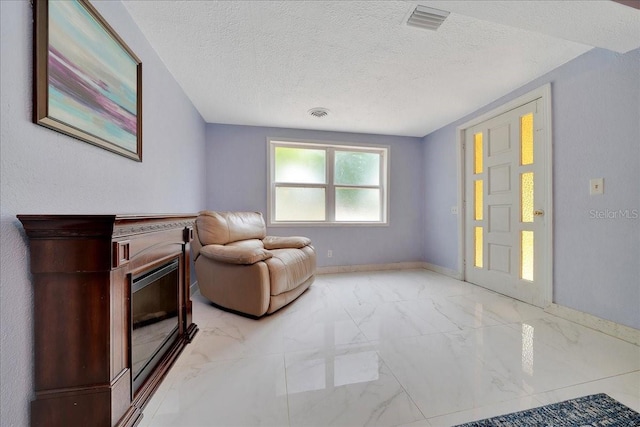 1322 NE 53rd St, Ocala, FL 34479 - living area with light marble finish flooring, a textured ceiling, baseboards, and a fireplace