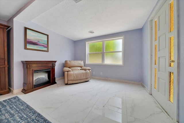 1322 NE 53rd St, Ocala, FL 34479 - sitting room featuring light marble finish flooring, a textured ceiling, and baseboards