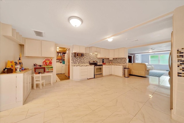 1322 NE 53rd St, Ocala, FL 34479 - kitchen with stainless steel appliances, washer and clothes dryer, light marble finish flooring, cream cabinetry, and tasteful backsplash