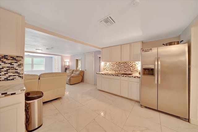 1322 NE 53rd St, Ocala, FL 34479 - kitchen featuring stainless steel fridge, tasteful backsplash, open floor plan, light marble finish floors, and cream cabinets