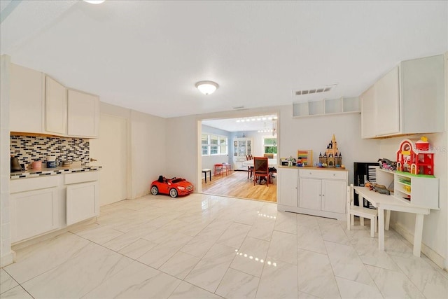 1322 NE 53rd St, Ocala, FL 34479 - kitchen with decorative backsplash and light marble finish floors