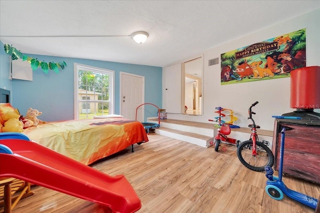 1322 NE 53rd St, Ocala, FL 34479 - bedroom with wood finished floors and a textured ceiling