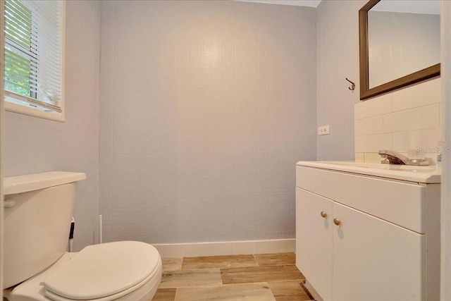 1322 NE 53rd St, Ocala, FL 34479 - bathroom with wood finished floors, toilet, vanity, baseboards, and backsplash