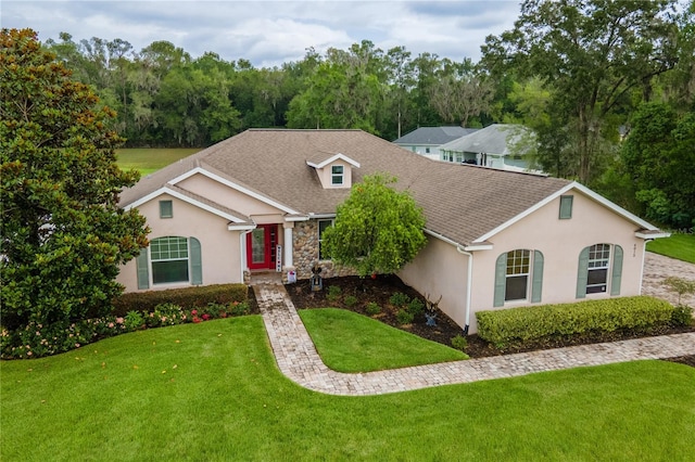 4015 SE 22nd St, Ocala, FL 34471 - view of front facade with a front yard, stucco siding, roof with shingles, and stone siding