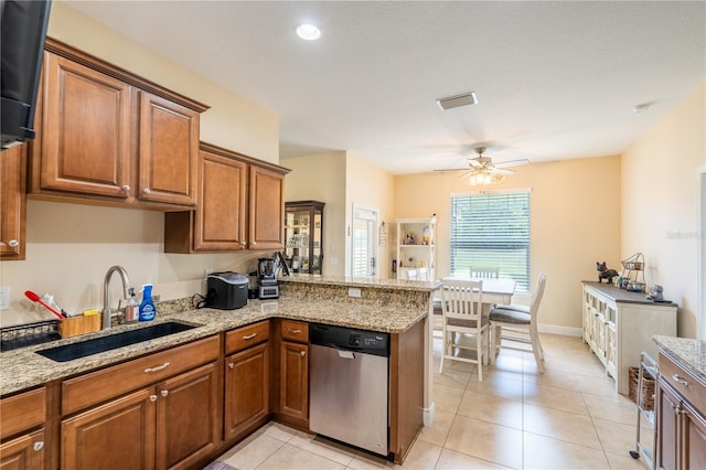 4015 SE 22nd St, Ocala, FL 34471 - kitchen with stainless steel dishwasher, a sink, brown cabinetry, a ceiling fan, and a peninsula