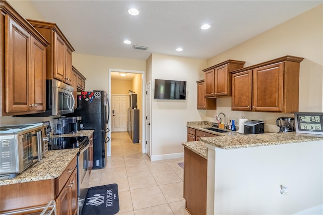 4015 SE 22nd St, Ocala, FL 34471 - kitchen with appliances with stainless steel finishes, a sink, brown cabinetry, a peninsula, and recessed lighting