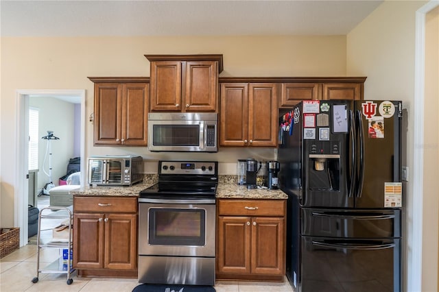 4015 SE 22nd St, Ocala, FL 34471 - kitchen with appliances with stainless steel finishes, light stone counters, brown cabinets, and light tile patterned flooring