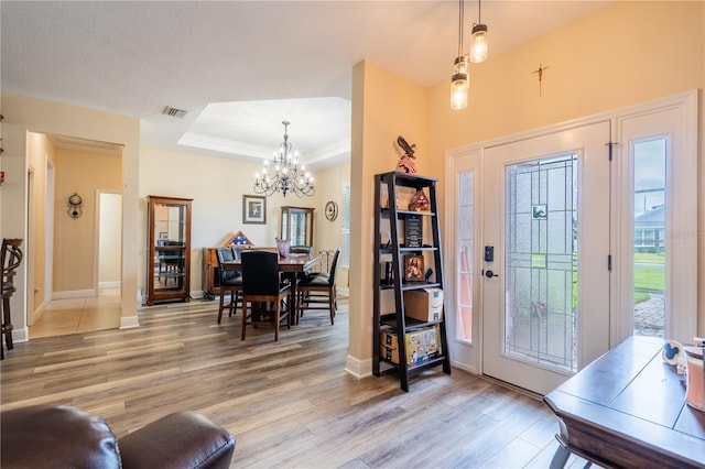 4015 SE 22nd St, Ocala, FL 34471 - foyer entrance featuring light wood finished floors, a chandelier, a raised ceiling, and baseboards