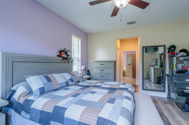 4015 SE 22nd St, Ocala, FL 34471 - bedroom with wood finished floors, ceiling fan, and ensuite bathroom