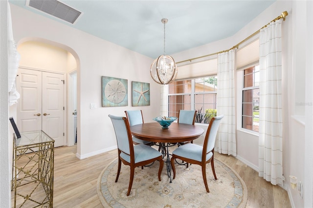 8303 SW 82nd Cir, Ocala, FL 34481 - dining space with light wood-style floors, arched walkways, baseboards, and a chandelier