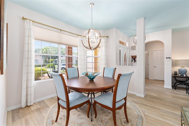 8303 SW 82nd Cir, Ocala, FL 34481 - dining room featuring a chandelier, light wood-type flooring, arched walkways, and baseboards