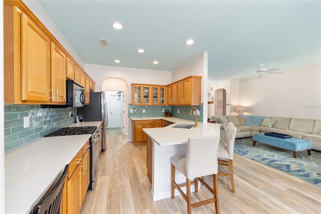 8303 SW 82nd Cir, Ocala, FL 34481 - kitchen featuring stainless steel range with gas cooktop, arched walkways, a breakfast bar area, a sink, and open floor plan