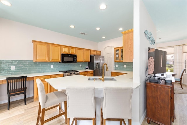 8303 SW 82nd Cir, Ocala, FL 34481 - kitchen featuring stainless steel appliances, a sink, light countertops, a peninsula, and light wood finished floors