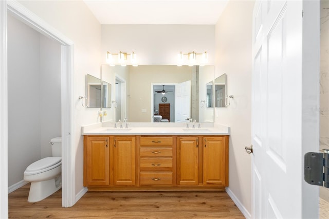 8303 SW 82nd Cir, Ocala, FL 34481 - full bathroom with double vanity, wood finished floors, toilet, and a ceiling fan