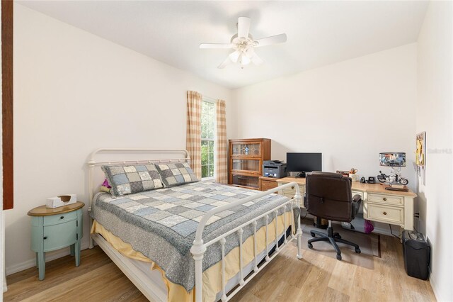 8303 SW 82nd Cir, Ocala, FL 34481 - bedroom featuring light wood-style floors, an office area, a ceiling fan, and baseboards