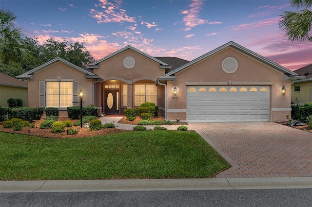 8303 SW 82nd Cir, Ocala, FL 34481 - view of front of property featuring stucco siding, an attached garage, decorative driveway, and a front lawn