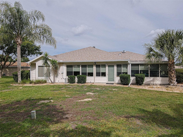 13863 SE 85th Cir, Summerfield, FL 34491 - rear view of house with a lawn, a sunroom, and roof with shingles