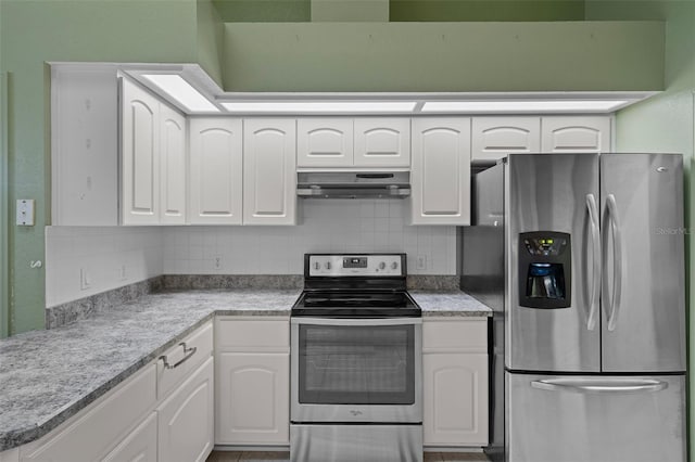 11 Calendula Ct E, Homosassa, FL 34446 - kitchen with appliances with stainless steel finishes, under cabinet range hood, tasteful backsplash, white cabinets, and light countertops