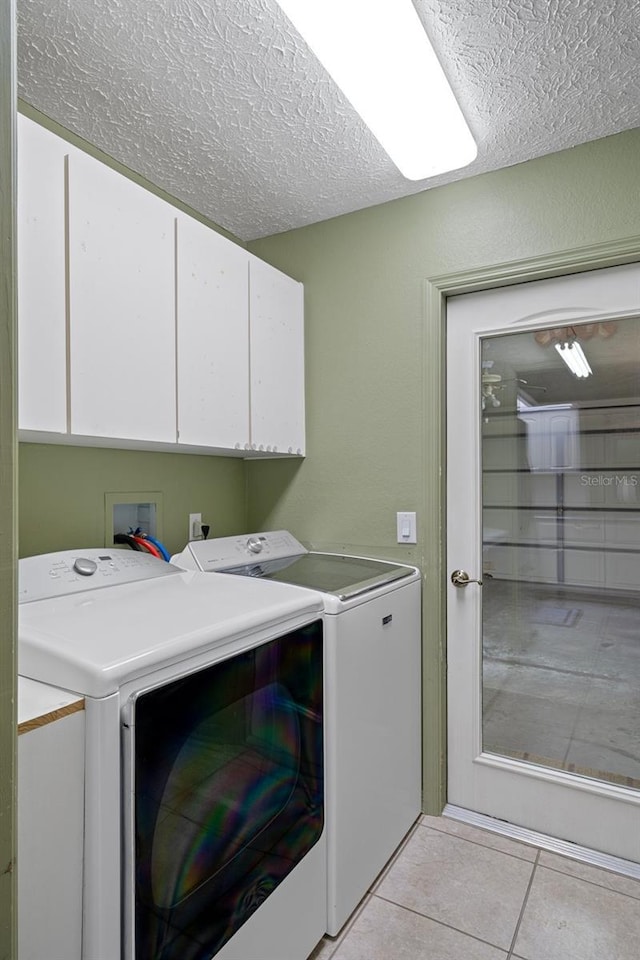 11 Calendula Ct E, Homosassa, FL 34446 - laundry area featuring independent washer and dryer, cabinet space, a textured ceiling, and light tile patterned floors