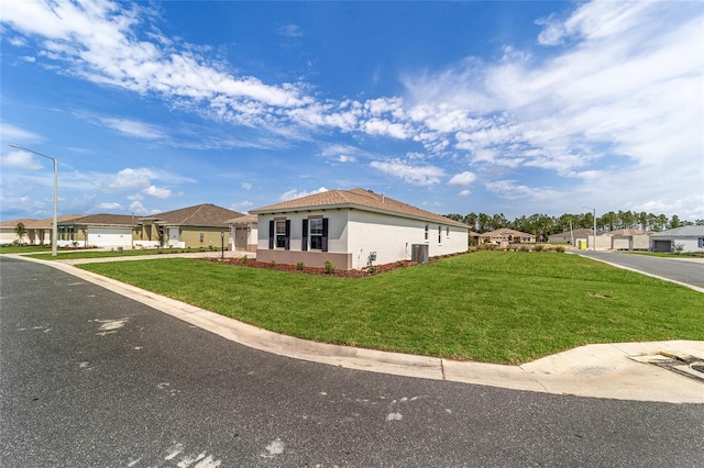 10553 SW 98th Pl, Ocala, FL 34481 - view of front facade featuring stucco siding, a front lawn, central air condition unit, and a residential view